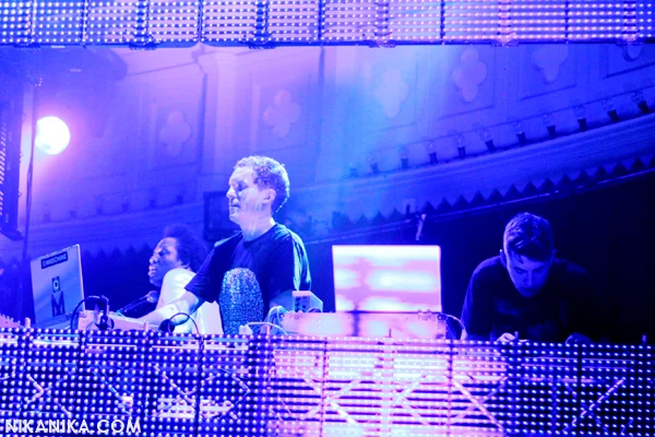 Magnetic Man performing behind a bank of equipment under blue and violet lights at Paradiso.